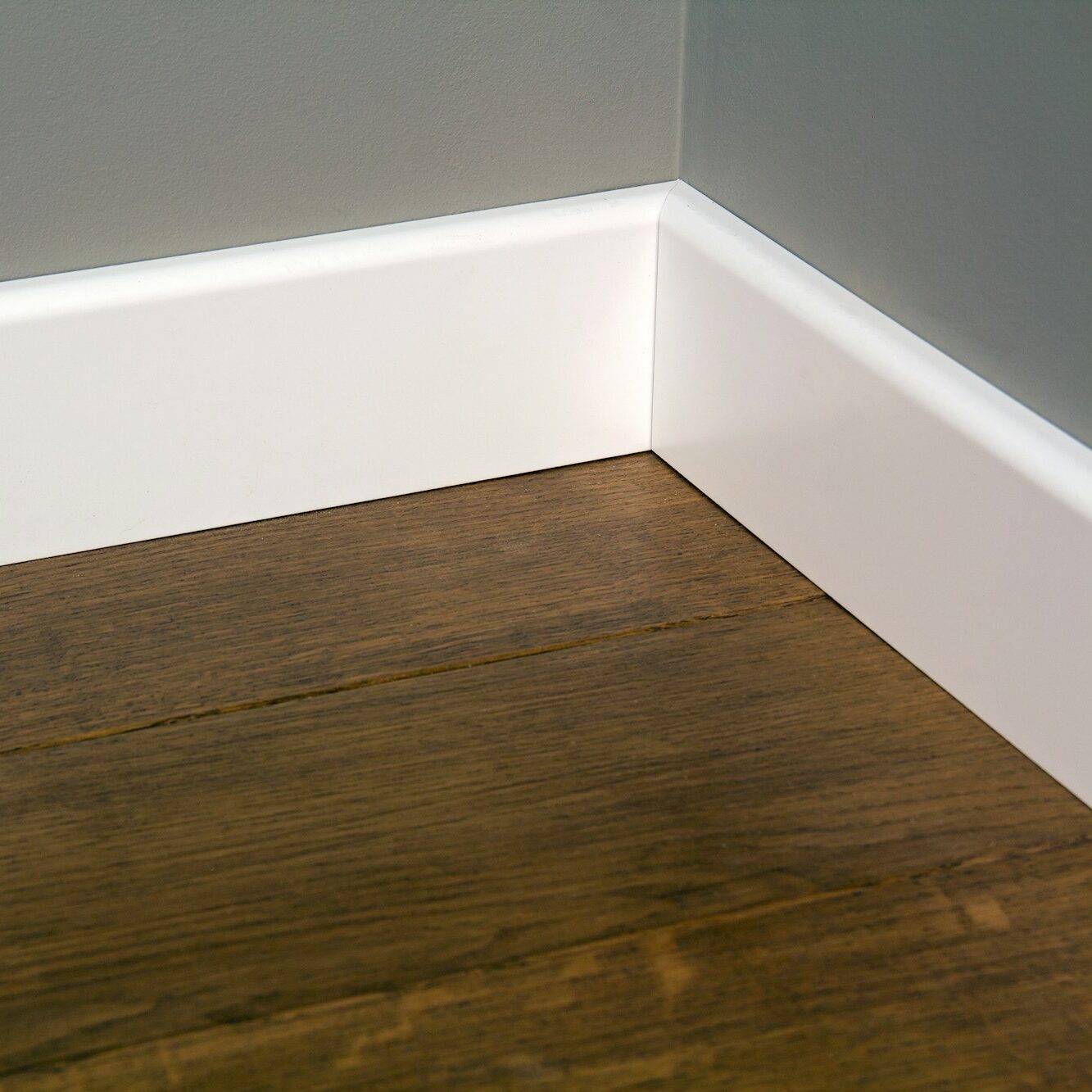 Close up of white plastic plinths on dark wooden oak floor parquet